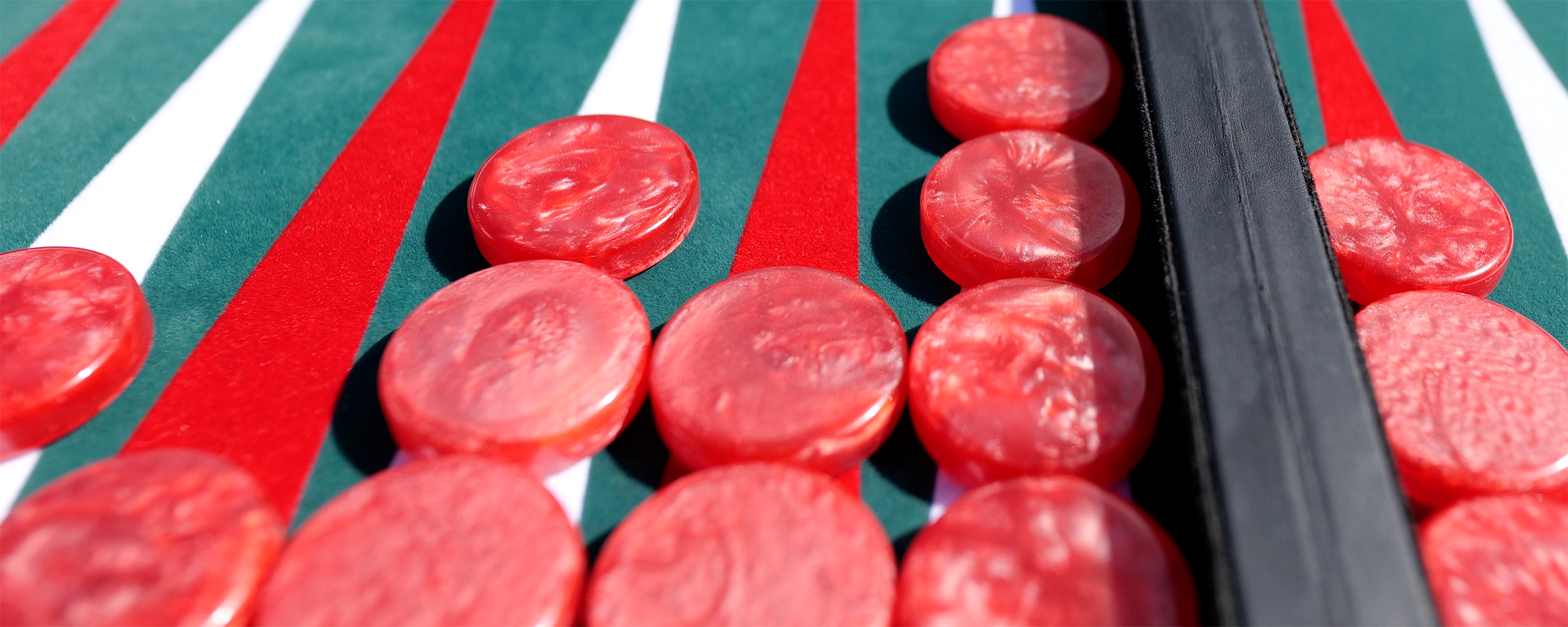 Red checkers on green backgammon board.