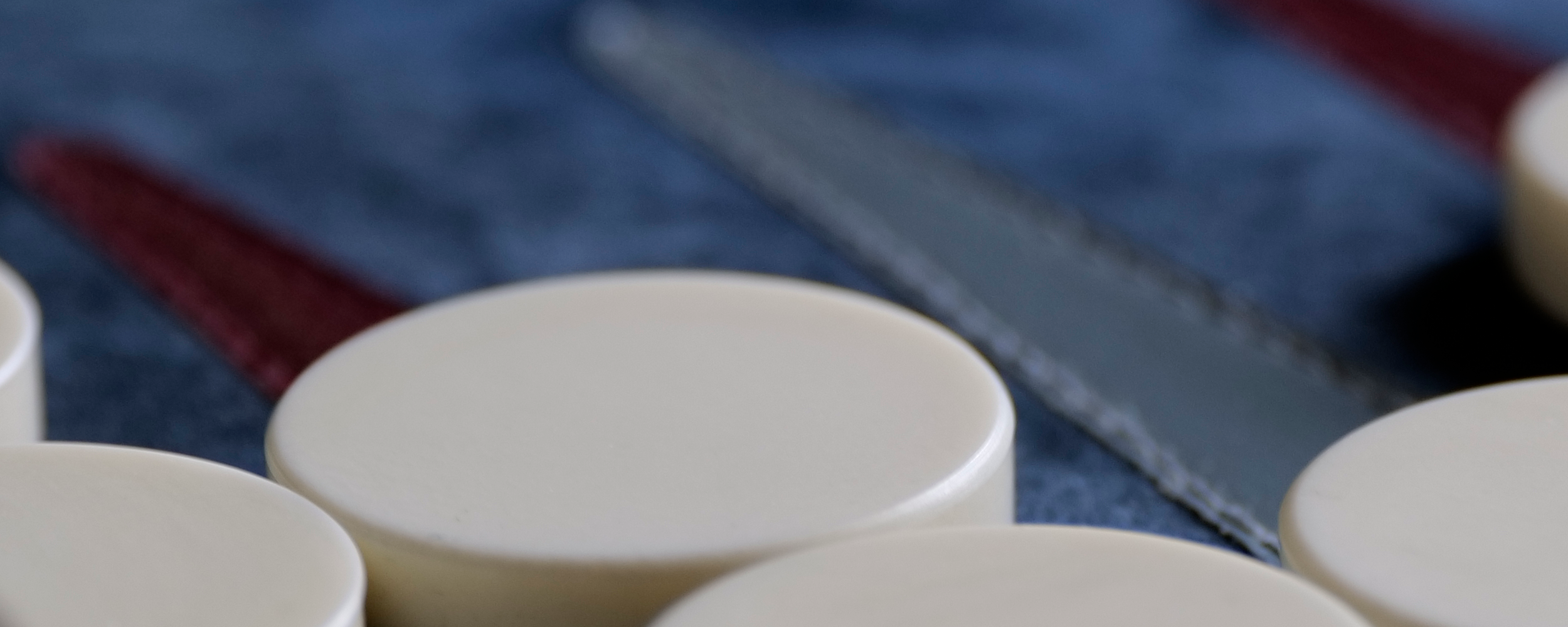 Close up of white checkers on blue backgammon board.